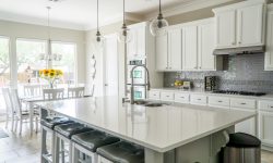 Spacious modern kitchen with white cabinets and island in natural light.