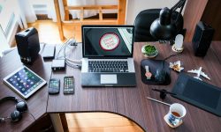 A contemporary office desk setup with laptops, gadgets, and accessories, creating a tech-savvy workplace.